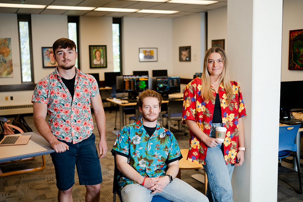 From l-r, Kieran MacDonough '24, Evan Coffey '24, and Kaela Frenchman '24 don Hawaiian shirts to honor their late professor,Scott Deacle.