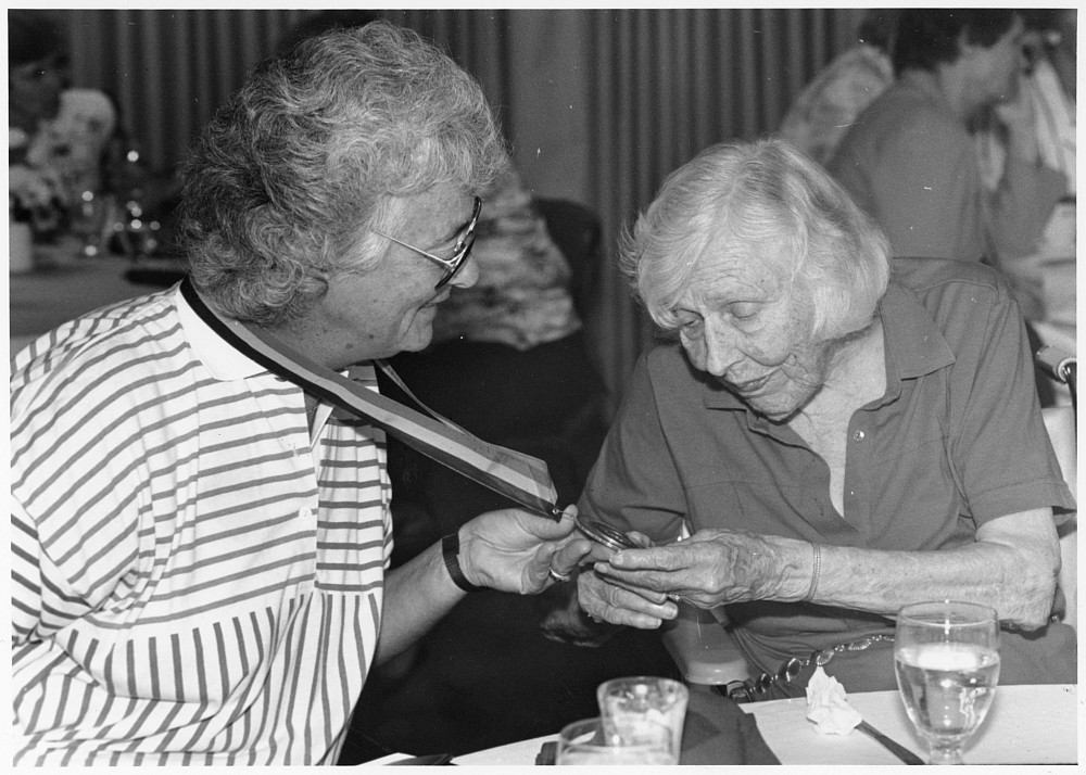 Gros (left) shows Eleanor Frost Snell her Snell Chair of Healthand Physical Education medallion. 