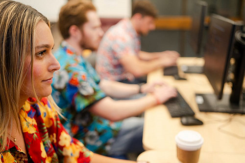 Student with coffee at a Bloomberg terminal.