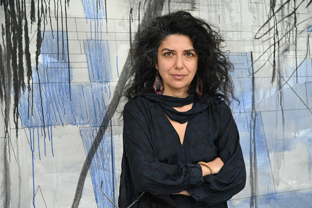 Bahar Behbahani stands in front of Immigrant Flora: Rising Under.