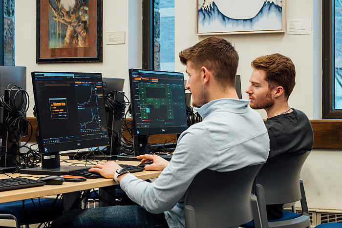 Nick Troha '24 (left) and Evan Coffey '24 work on the new Bloomberg terminals in the Myrin Library.