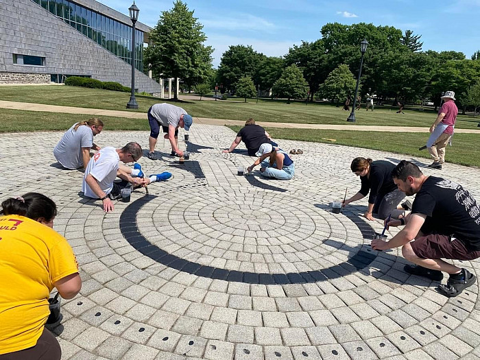 Photo of faculty and staff volunteers helping repaint the labyrinth located on campus.