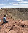 Ursinus students looking down over rim of a meteor crater during a Planetary Crater Consortium (PCC) field trip in August 2019.