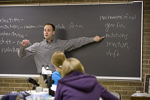 Photo of Cory Straub teaching in front of a chalkboard