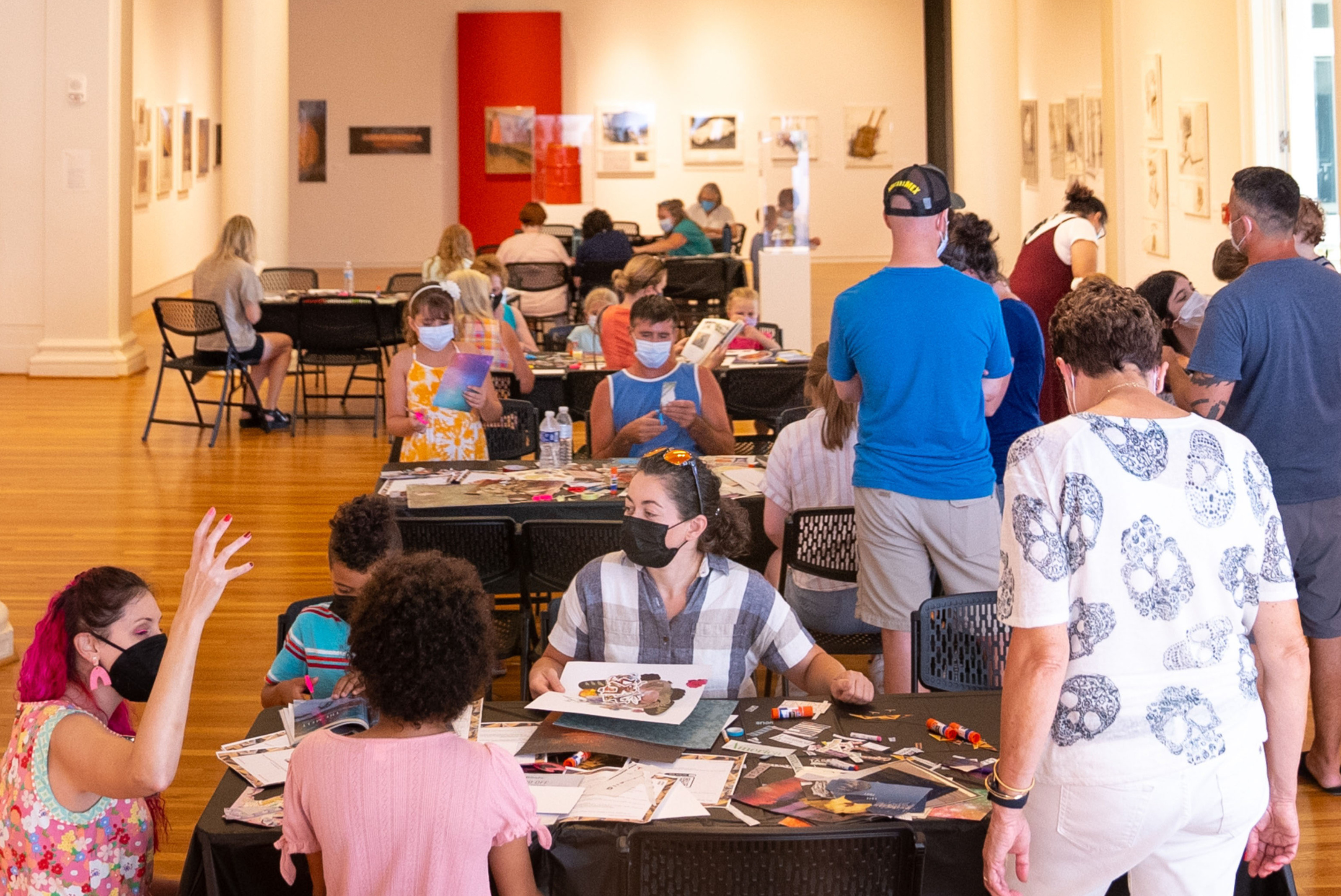 Collage Night at the Berman. Families from the community work on collages at tables in the Main Gallery of the museum.