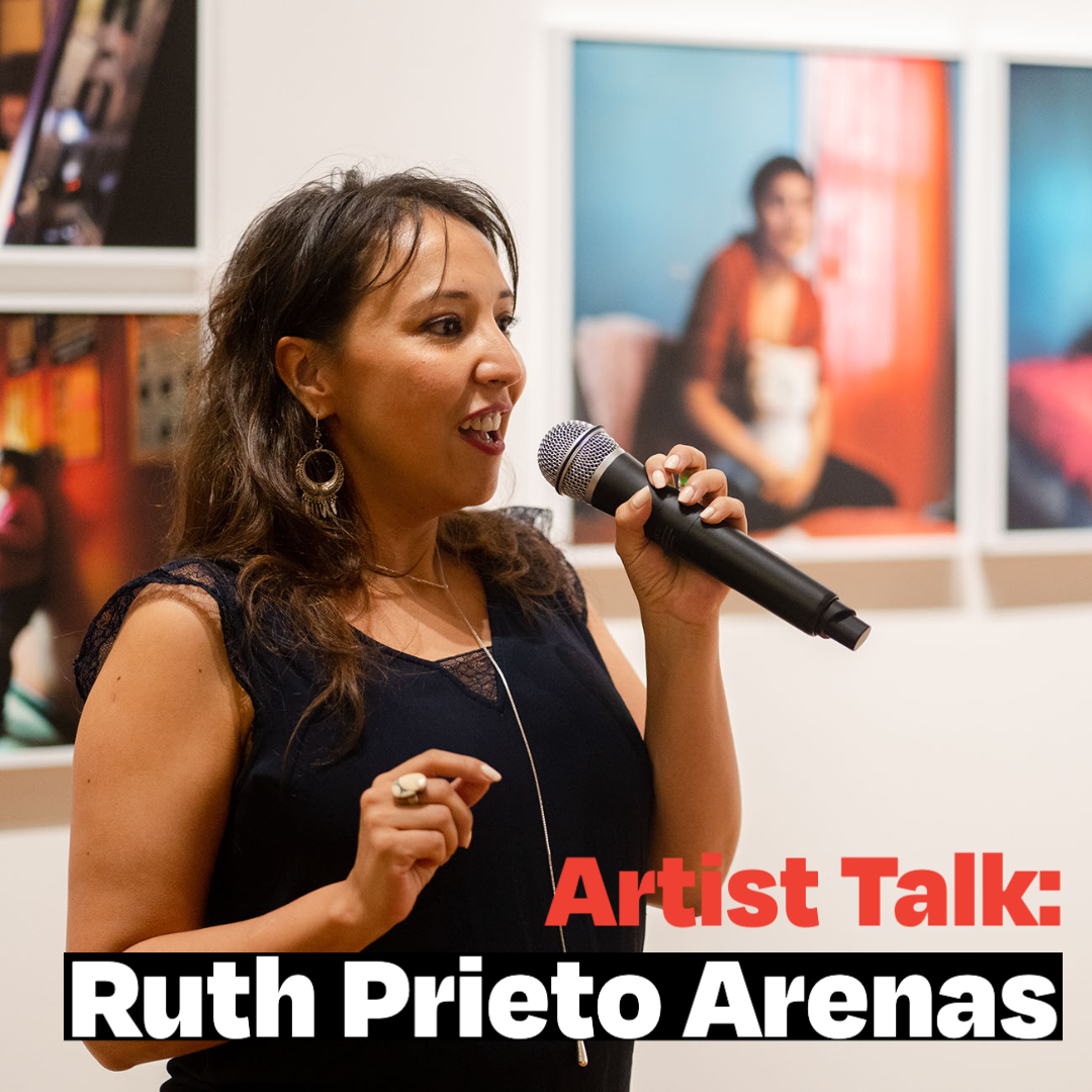 Ruth Prieto Arenas speaking in front of her displayed photographs.