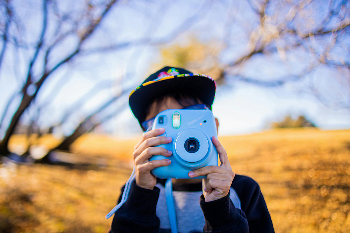 Child holding a polaroid camera