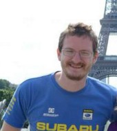 Stephen Hennion standing in front of the Eiffel Tower