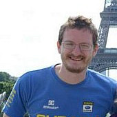 Stephen Hennion standing in front of the Eiffel Tower