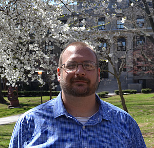 Tristan Ashcroft standing in front of a blossoming tree