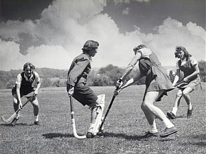 Four Students playing field hockey in the 1950s.