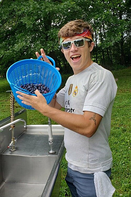 2019 Farm Fellow Brandon Slaboda (Class of '22) showing off some of our blueberries, one of our most popular crops.